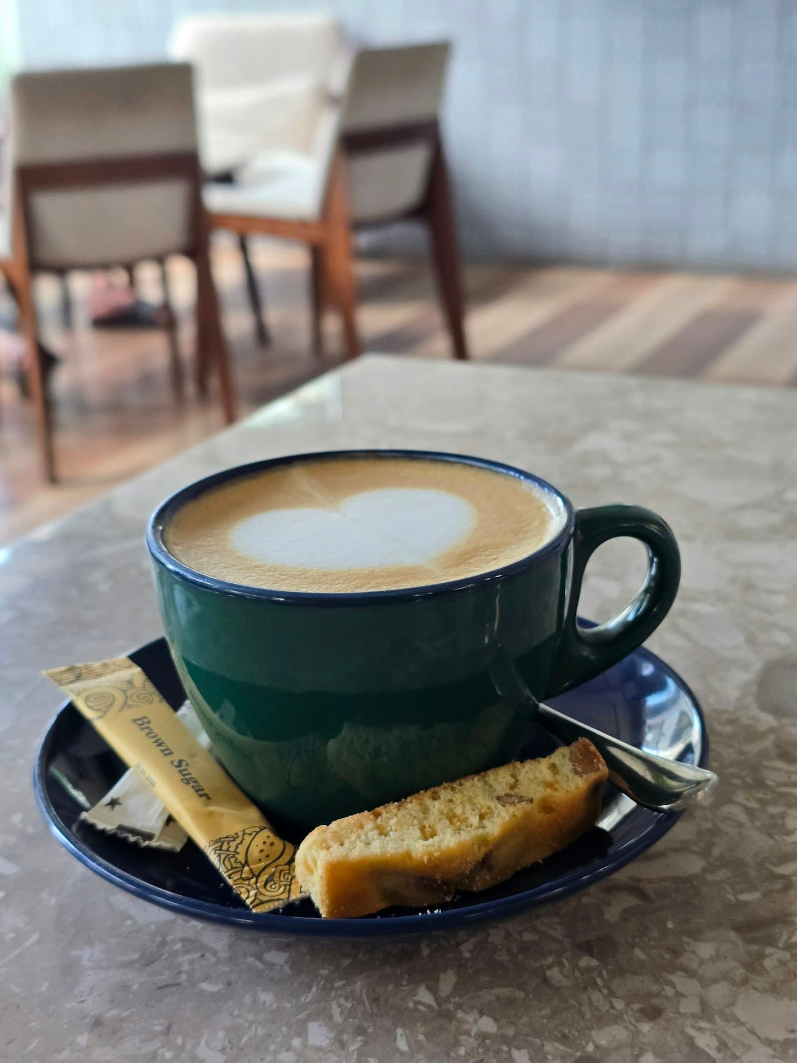 Šoljica kafe s mliječnom pjenom na stolu